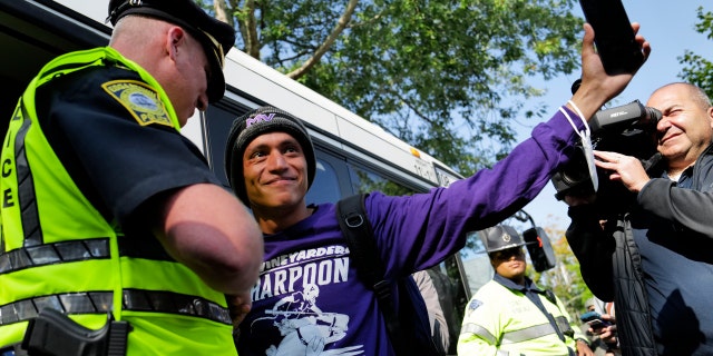 Carlos, a Venezuelan migrant, waves to volunteers before boarding a bus to the Vineyard Haven ferry terminal outside of St. Andrew's Parish House at Martha's Vineyard, Massachusetts, Sept.  16. Two plans of migrants from Venezuela arrived suddenly two days prior causing the local community to mobilize and create a makeshift shelter at the church. 