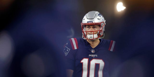 New England Patriots quarterback Mac Jones stands on the sideline during an offensive drive during the second half of a game against the Chicago Bears, Monday, Oct. 24, 2022, in Foxborough, Mass.