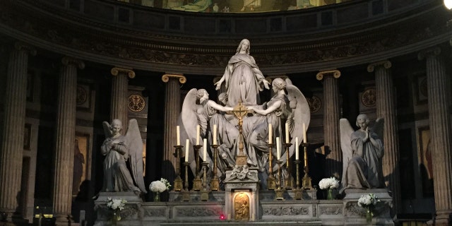 Wearing a crown of thorn and a blue veil to mock Jesus Christ and the Virgin Mary, Bouton carried animal livers to symbolize an aborted baby at the church's altar.