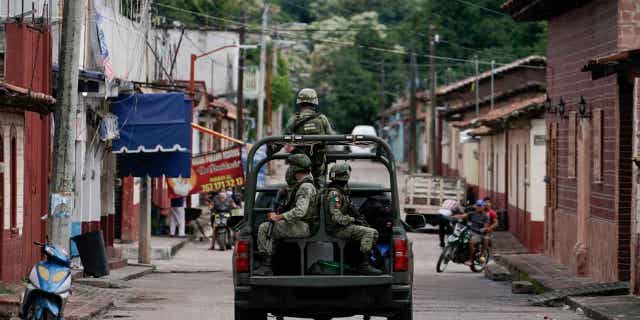 Soldiers patrol after a mass shooting that killed 20 people in San Miguel Totolapan, Mexico, on Oct. 6, 2022. Mexico approved a constitutional reform that extends the use of the military for public security to 2028.