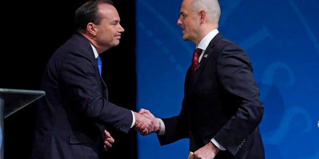 Republican Sen. Mike Lee and Evan McMullin shake hands following their televised debate, Monday, Oct. 17, 2022, in Orem, Utah.