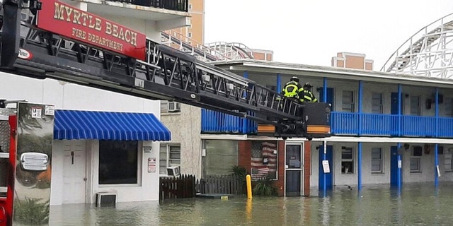 This photo provided by the Myrtle Beach Fire Dept., crews respond to rescue people who were trapped on the second floor due to flooding caused by Hurricane Ian, on Friday, Sept. 30, 2022 in Myrtle Beach, S.C. 