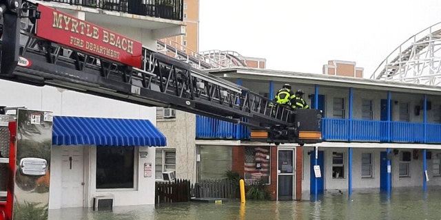 This photo provided by the Myrtle Beach Fire Dept., crews respond to rescue people who were trapped on the second floor due to flooding caused by Hurricane Ian, on Friday, Sept. 30, 2022 in Myrtle Beach, S.C.
