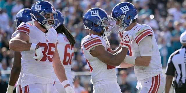 New York Giants quarterback Daniel Jones, right, celebrates with teammates after he scored on a 1-yard touchdown run against the Jaguars, Sunday, Oct. 23, 2022, in Jacksonville, Florida.