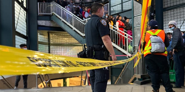 FILE PHOTO: An NYPD officer stands behind caution tape in the subway. 