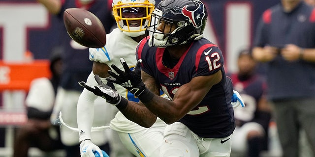 Houston Texans wide receiver Nico Collins (12) pulls in a catch in front of Los Angeles Chargers cornerback J.C. Jackson (27) during the second half of an NFL football game Sunday, Oct. 2, 2022, in Houston. 