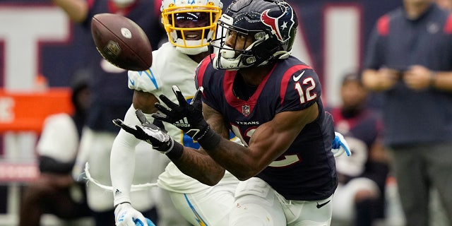 Houston Texans wide receiver Nico Collins (12) pulls in a catch in front of Los Angeles Chargers cornerback J.C. Jackson (27) during the second half of an NFL football game Sunday, Oct. 2, 2022, in Houston.
