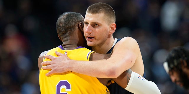 Denver Nuggets center Nikola Jokic, right, hugs Los Angeles Lakers forward LeBron James, #6, in the first half of an NBA basketball game Wednesday, Oct. 26, 2022, in Denver. 
