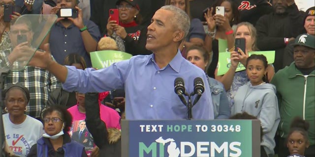 Former President Barack Obama reacts to being interrupted by a man during a Saturday rally in Michigan.