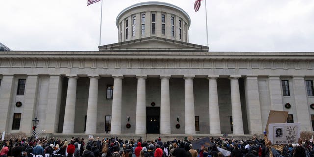 A group of people protests outside the Ohio Statehouse in Columbus, Ohio.