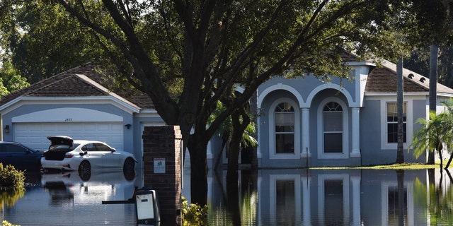 ORLANDO, FLORIDA, UNITED STATES - OCTOBER 1: Water reflections of a home and a car are seen in a neighborhood that was flooded by rain from Hurricane Ian on October 1, 2022, in Orlando, Florida. 