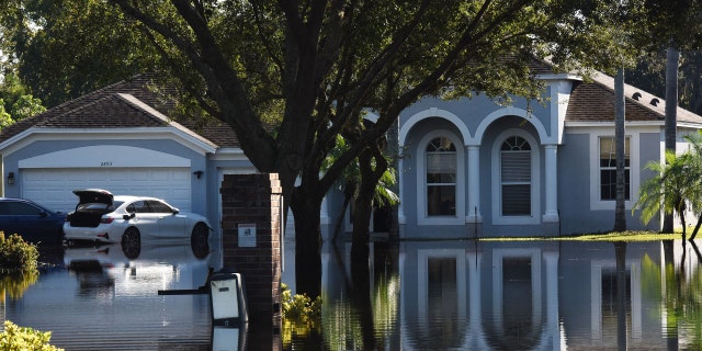 ORLANDO, FLORIDA, UNITED STATES - OCTOBER 1: Water reflections of a home and a car are seen in a neighborhood that was flooded by rain from Hurricane Ian on October 1, 2022, in Orlando, Florida. 