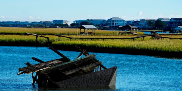 A boat house is overturned in the inlet between Pawleys Island and the mainland following winds and rain from Hurricane Ian on Saturday, Oct. 1, 2022, in Pawleys Island, S.C.