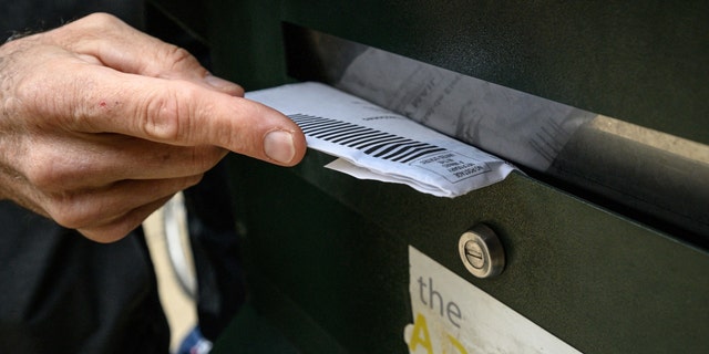 A voter casts a ballot at a drop box outside Philadelphia City Hall on Oct. 24, 2022.