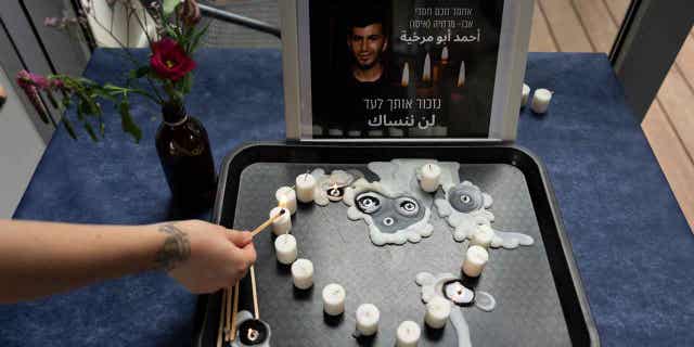 A volunteer lights a candle during a vigil for Ahmad Abu Murkhiyeh, a 25-year-old gay Palestinian man, whose remains were found on the side of the road in the occupied West Bank.
