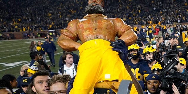 Mike Sainlistill of Michigan carries the Paul Bunyan Trophy after the Michigan State University game in Ann Arbor on Saturday, Oct. 29, 2022.