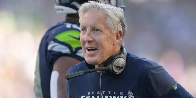 Seattle Seahawks head coach Pete Carroll greets players during the second half of his team's NFL football game against the Arizona Cardinals in Seattle, Sunday, Oct. 16, 2022. 