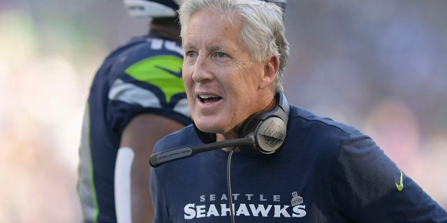 Seattle Seahawks head coach Pete Carroll greets players during the second half of his team's NFL football game against the Arizona Cardinals in Seattle, Sunday, Oct. 16, 2022.