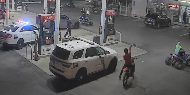 Image shows dirt-bike rider hurling an item at a Philadelphia police vehicle on Oct. 16, 2022.