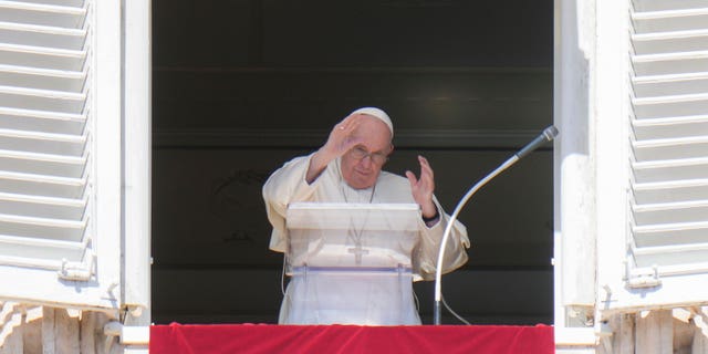 Pope Francis waves during the Angelus noon prayer from the window of his studio overlooking St. Peter's Square in the Vatican, Sunday October 2, 2022. 