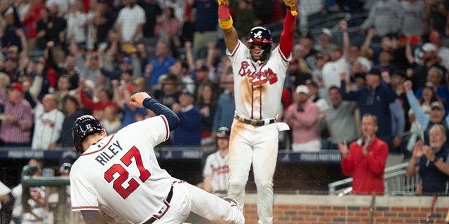 Atlanta Braves Ronald Acuna Jr. and Austin Riley score on a single hit by Travis d'Arnaud in the third inning of a baseball against the New York Mets, Sunday, Oct. 2, 2022, in Atlanta.