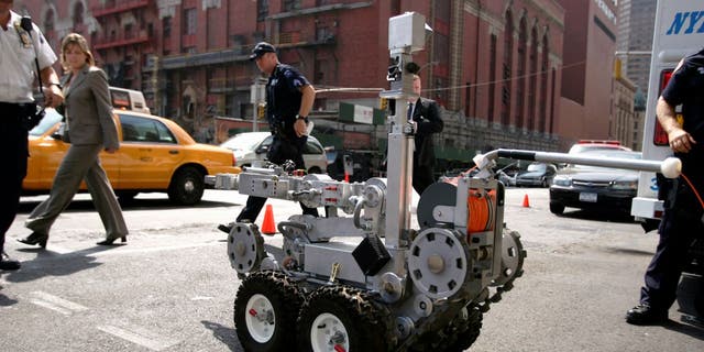 Officers from New York Police Department's Emergency Services Unit operate a remote controlled robot on a street near the United Nations building on September 14, 2005 in New York City. A San Francisco Police Department draft policy proposes that such robots can use lethal force in certain instances.