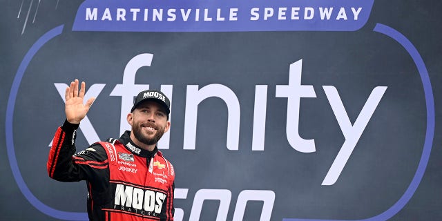 Ross Chastain waves to fans as he walks onstage during driver intros prior to the Xfinity 500 at Martinsville Speedway on Oct. 30, 2022, in Martinsville, Virginia.