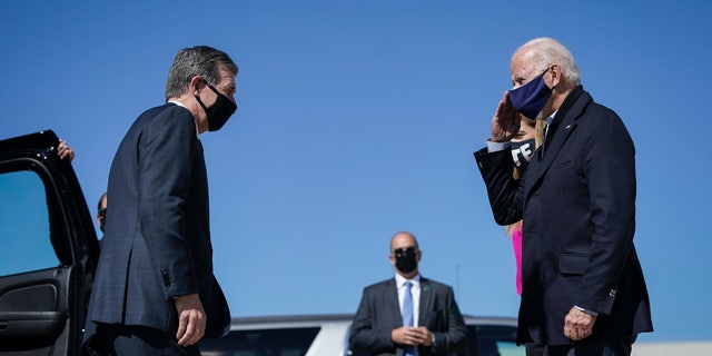 Democratic Gov. Roy Cooper greets then-presidential nominee Joe Biden at Raleigh-Durham International Airport on Oct. 18, 2020, in Morrisville, North Carolina.