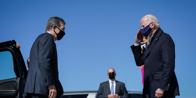 Democratic Gov. Roy Cooper greets then-presidential candidate Joe Biden at Raleigh-Durham International Airport in Morrisville, North Carolina, Oct. 18, 2020.