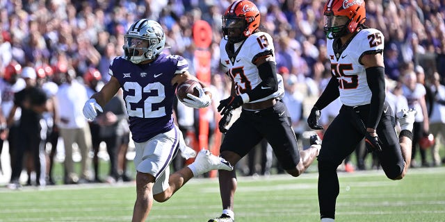 MANHATTAN, KS - OCTOBER 29:  Running back Deuce Vaughn #22 of the Kansas State Wildcats rushes for a touchdown past safety Thomas Harper #13 of the Oklahoma State Cowboys during the first half at Bill Snyder Family Football Stadium on October 29, 2022 in Manhattan, Kansas.