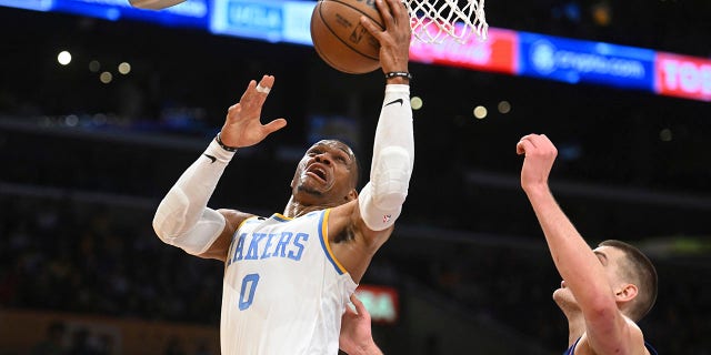 Los Angeles Lakers guard Russell Westbrook #0 drives to the basket against Denver Nuggets center Nikola Jokic #15 during the first half of an NBA basketball game Sunday, Oct. 30 2022 in Los Angeles.