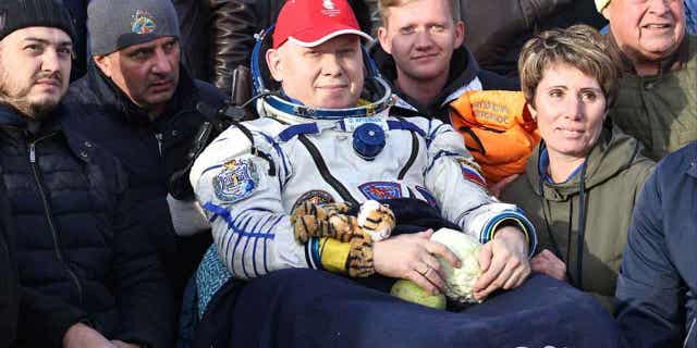 Russian cosmonaut Oleg Artemyev sits in a chair shortly after the Russian Soyuz MS-21 space capsule landed southeast of Zhezkazgan, Kazakhstan, September 29, 2022. Artemyev led a colleague down a dark road to the outside Moscow less than three weeks back from its last orbital mission.