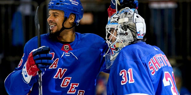 New York Rangers right wing Ryan Reaves, left, and goaltender Igor Shesterkin (31) celebrate following the team's 3-1 win in a game against the Tampa Bay Lightning Oct. 11, 2022, in New York.