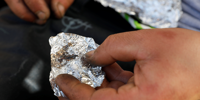 A man living on the streets displays what he says is the synthetic drug fentanyl, across the street from where San Francisco mayor London Breed just held a news conference introducing legislation in curbing the rise of deadly overdoses in the city, at the Tenderloin section of San Francisco Feb. 27, 2020.