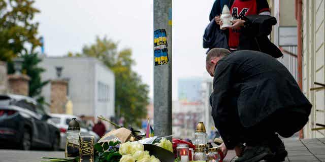 People lay flowers and light candles at the scene of Wednesday's attack, which some officials believe was a hate crime, on Zamocka Street in Bratislava, Slovakia, on Oct. 13, 2022. Slovakia’s police say they found the body of the suspected shooter.