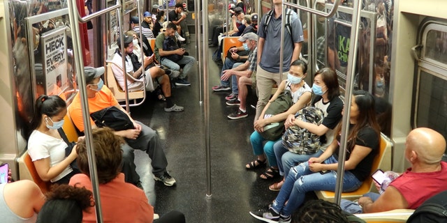People ride in an F train subway car on July 15, 2022, in New York City. 