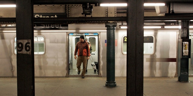 Commuters exit a subway train at the 96th street station in New York, Dec. 23, 2005. 