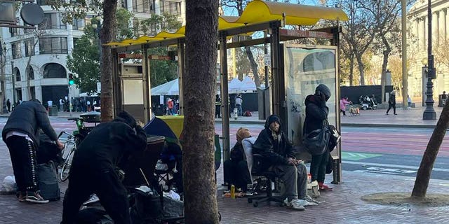 A San Francisco bus stop crowded with homeless people.