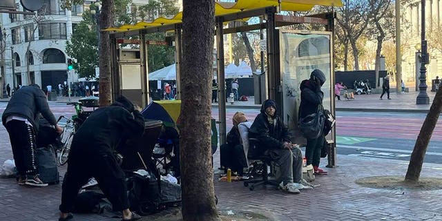 San Francisco bus stop crowded by homeless people.