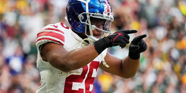 New York Giants running back Saquon Barkley celebrates a touchdown against the Green Bay Packers in London, Sunday, Oct. 9, 2022.