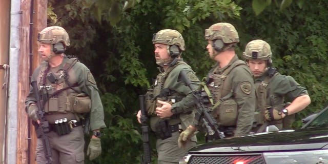 Police prepare to enter the hotel where a man was found shot to death in Poughkeepsie, NY, Sunday October 2, 2022.