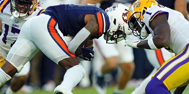 LSU cornerback Sevyn Banks (1) moves in to tackle Auburn cornerback Keionte Scott (6) on the opening kickoff in the first half of an NCAA college football game, Saturday, Oct. 1, 2022, in Auburn, Ala.
