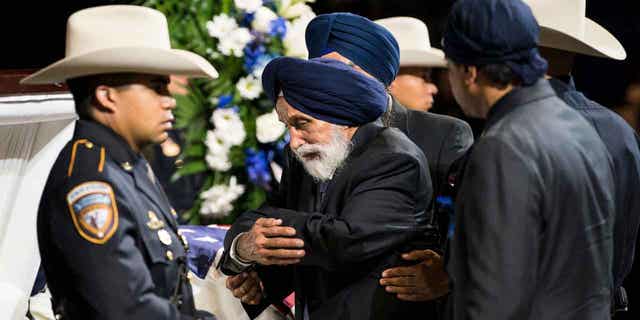 Pyara Singh Dhaliwal, father of Harris County Sheriff's deputy Sandeep Dhaliwal, center, pays respects to his son during his funeral at Berry Center on Oct. 2, 2019, in Houston. 