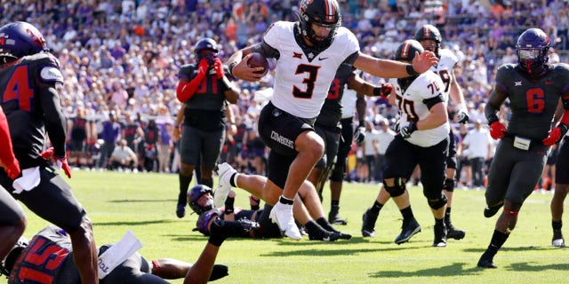 Spencer Sanders (3) of the Oklahoma State Cowboys leaps across the goal line to score a touchdown against the TCU Horned Frogs during the first half at Amon G. Carter Stadium Oct. 15, 2022, in Fort Worth, Texas.