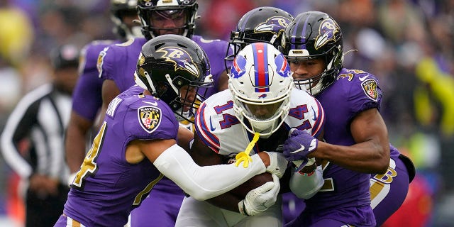Buffalo Bills wide receiver Stefon Diggs, #14, is stopped by Baltimore Ravens defenders in the first half of an NFL football game Sunday, Oct. 2, 2022, in Baltimore.