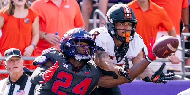 TCU cornerback Josh Newton (24) deflects a pass intended for Oklahoma State wide receiver Braydon Johnson (8) during the first half of a game in Fort Worth, Texas, Oct. 15, 2022.