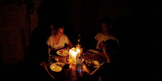A family has dinner during a blackout in the aftermath of Hurricane Ian in Havana, Cuba, Sept. 28, 2022.