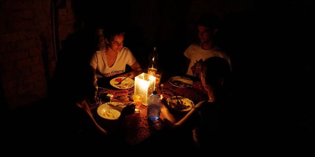 A family has dinner during a blackout in the aftermath of Hurricane Ian in Havana, Cuba, Sept. 28, 2022.