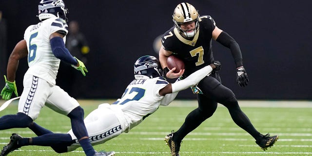 New Orleans Saints' Taysom Hill (7) carries the ball as Seattle Seahawks cornerback Tre Brown tries to make the tackle during an NFL football game in New Orleans, Sunday, Oct. 9, 2022.