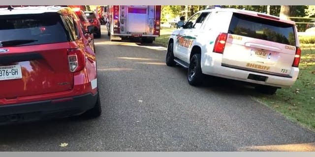 Police and fire personnel lined up outside the home where two children were killed in a dog attack.